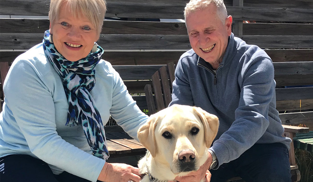 a smiling woman and man with a dog