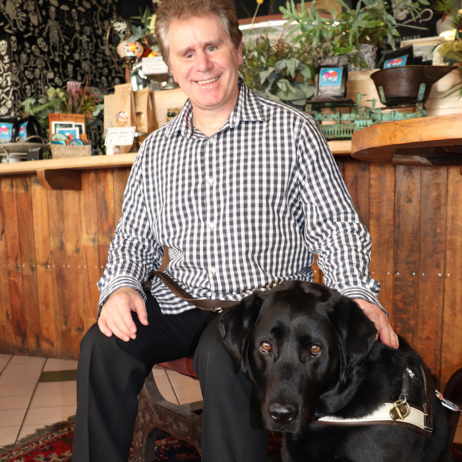 a smiling man and his Guide Dog