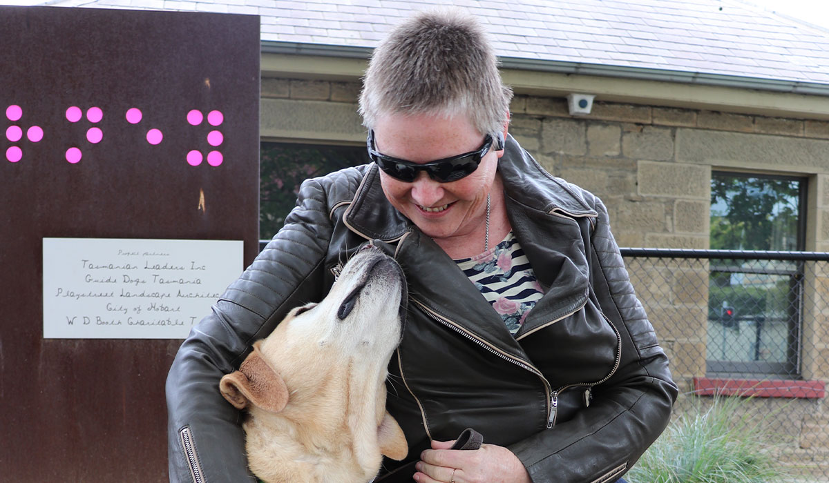 smiling lady looking at her Guide Dog