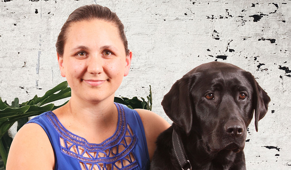 smiling woman with a guide dog