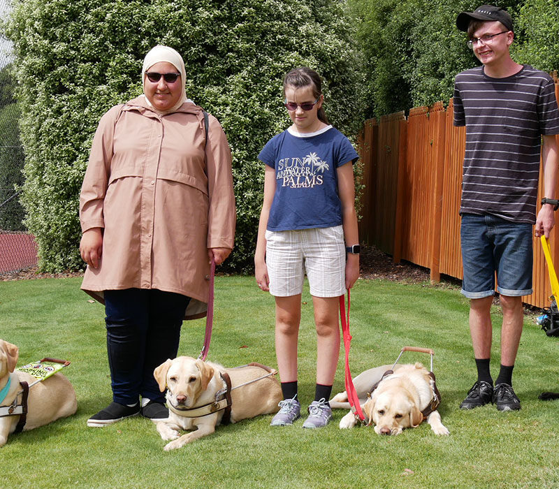 four young people standing next to Guide Dogs