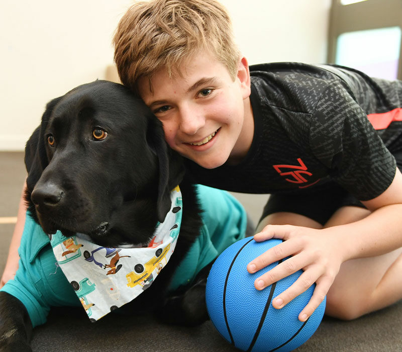 smiling young boy next to a dog in at shirt