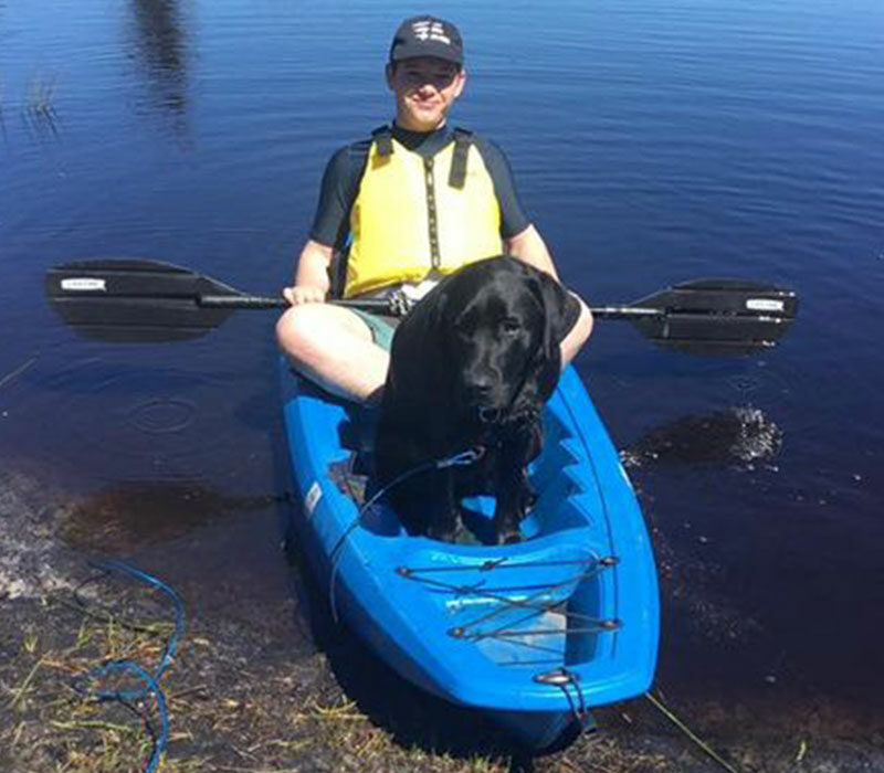 a pup and a young boy in a kayak