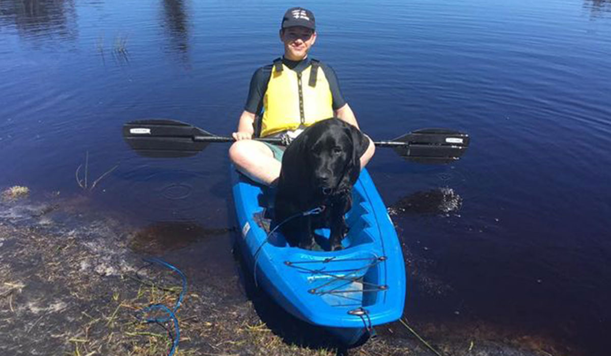 a pup and a young boy in a kayak