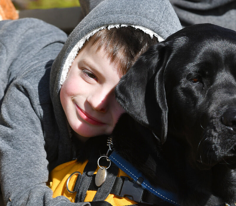 little boy hugging a dog