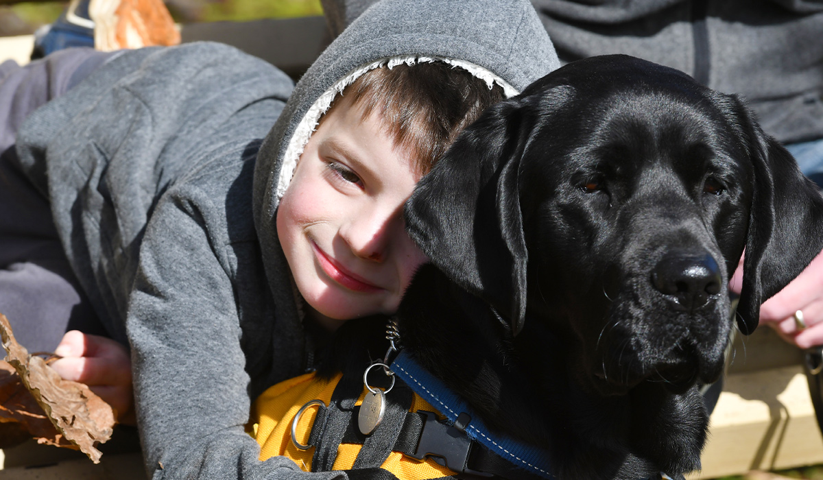 little boy hugging a dog