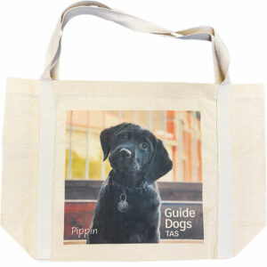 Canvas tote bag with photograph of black labrador puppy, Pippin and Guide Dogs Tasmania logo