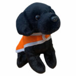 Black plush toy puppy with orange jacket