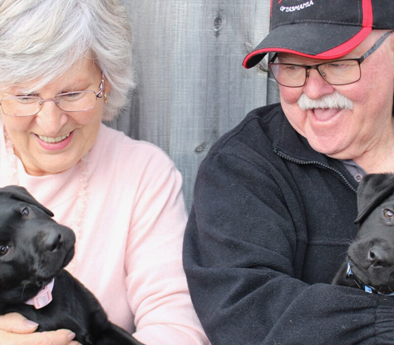 pauline and her husband holding two puppies