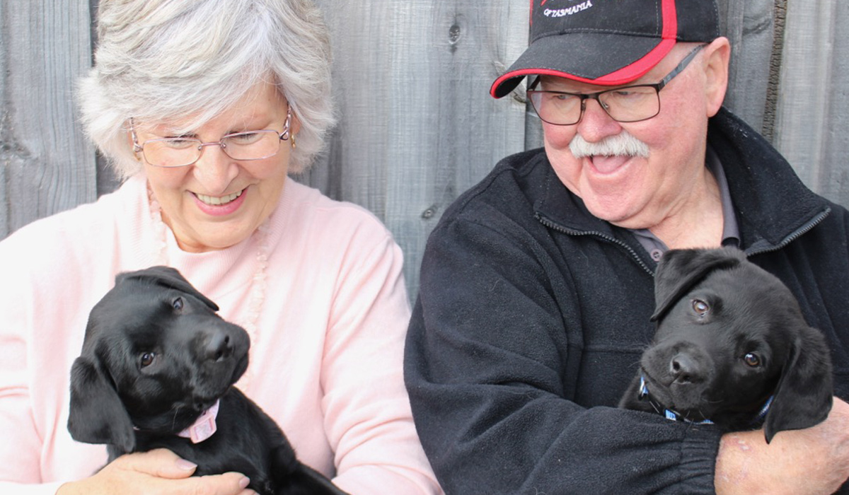 pauline and her husband holding two puppies