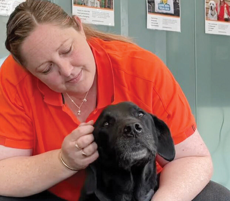 Kim patting a black Labrador