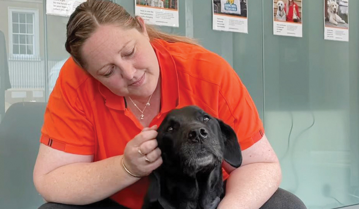 Kim patting a black Labrador