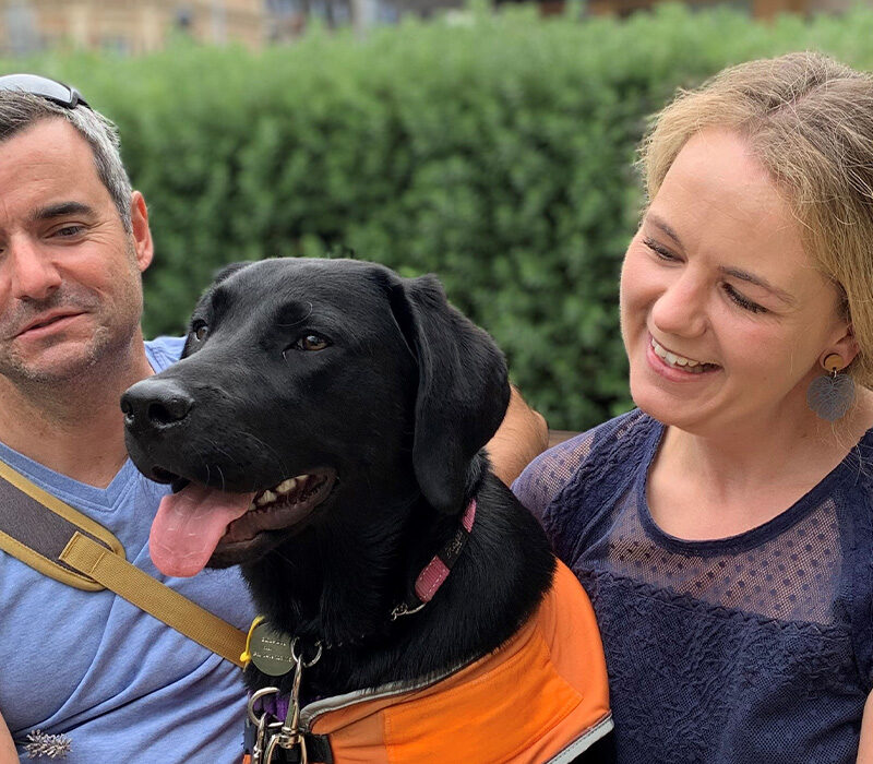 Two happy people with a Guide Dog in Training