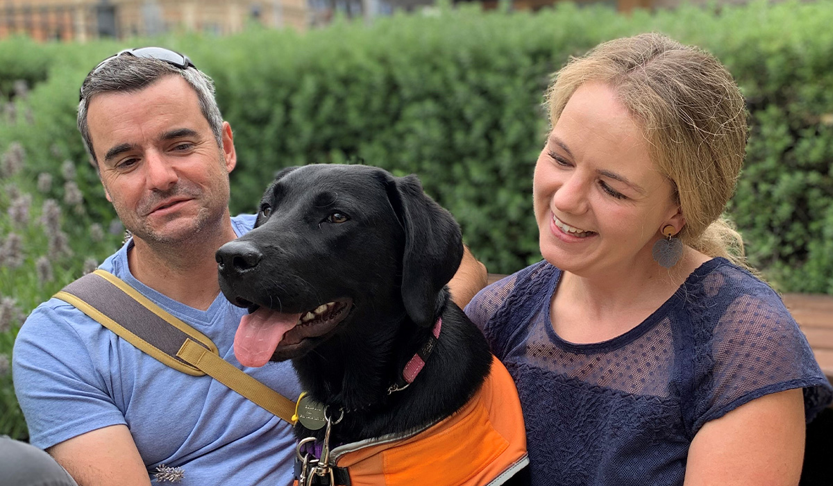 Two happy people with a Guide Dog in Training