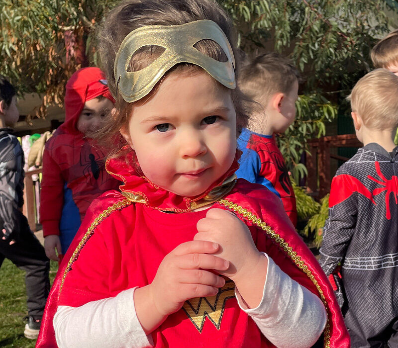 little girl wearing a hero costume