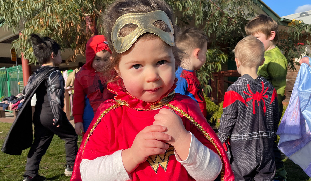little girl wearing a hero costume