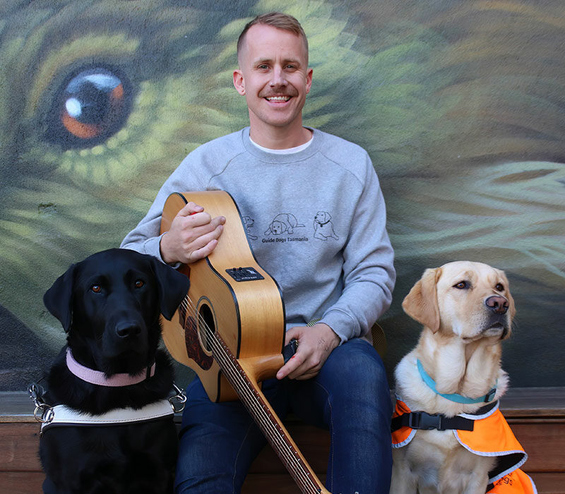 Tyler with his guitar and two dogs