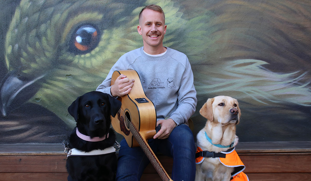 Tyler with his guitar and two dogs