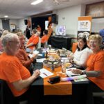 People sit around a quiz table looking happy